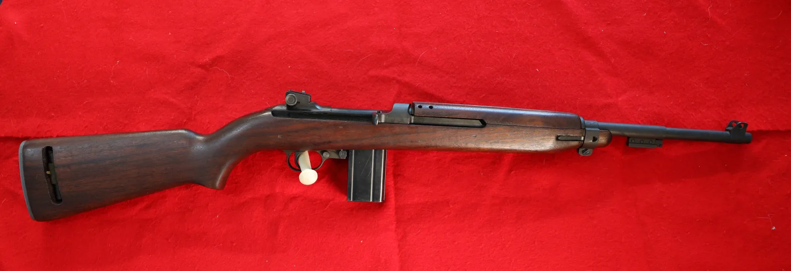 M1 Carbine with walnut stock laid out on red felt