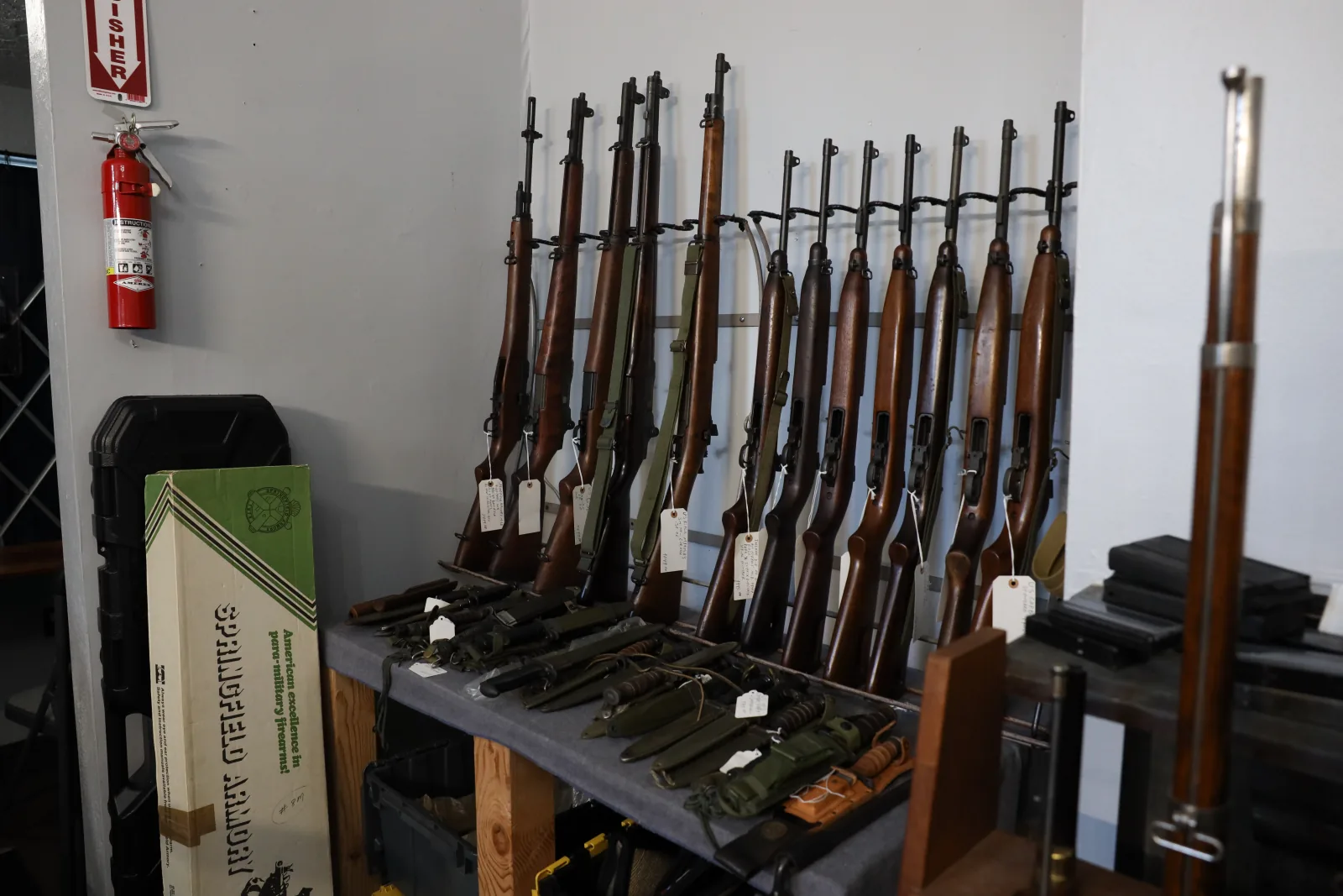 Military rifles and bayonets displayed in a corner of the shop